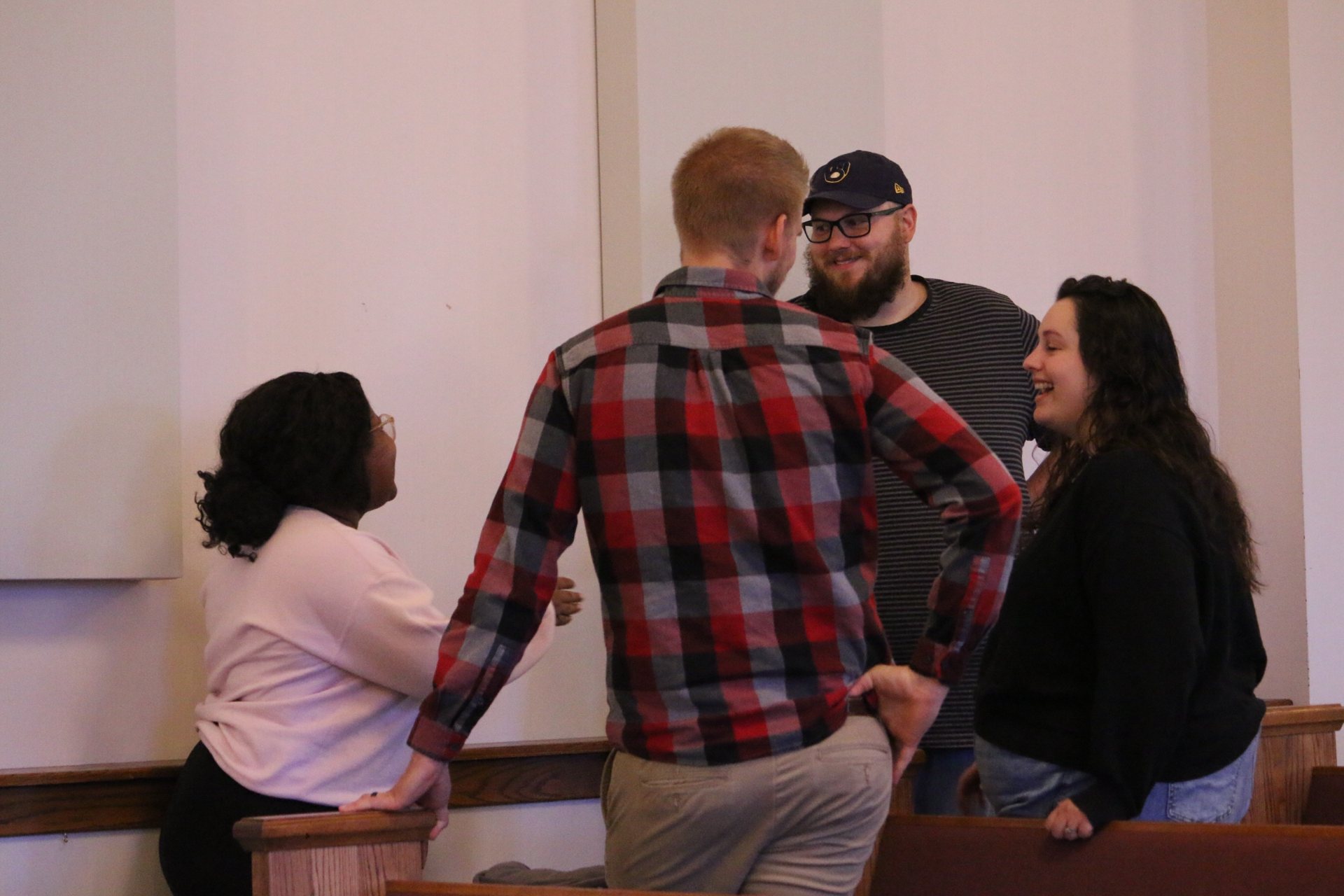 Friends talking between the pews after a Sunday service