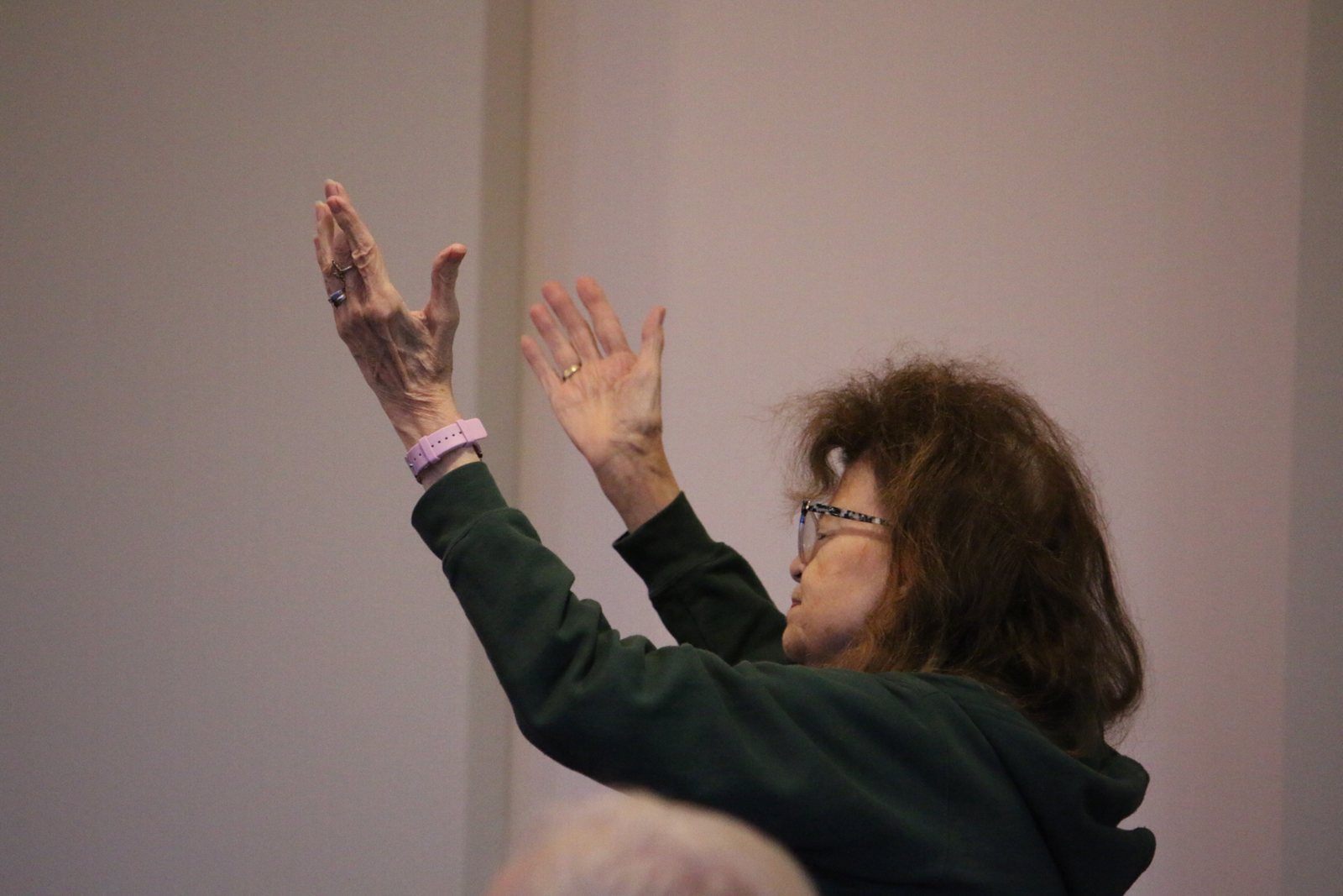 A woman lifts both hands in worship
